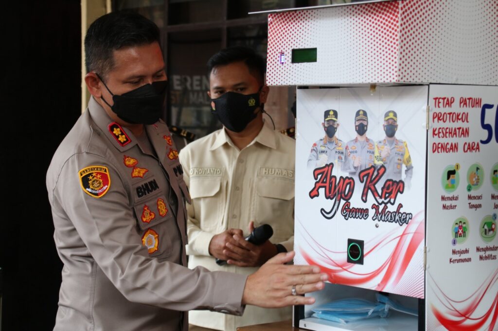 Kapolresta Malang Kota AKBP Budi Hermanto S.I.K., M.Si memperagakan penggunaan Dispenser Masker dengan teknologi tanpa sentuh di Mapolresta Malang Kota, Kamis (14/10/2021)