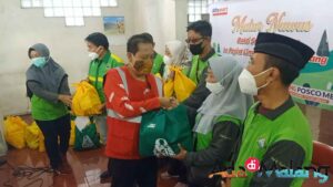 Corporate Communication Regional Manager PT Sumber Alfaria Trijaya, M. Faruq Asrori menyerahkan bantuan paket sembako kepada Kader Lingkungan Kota Malang