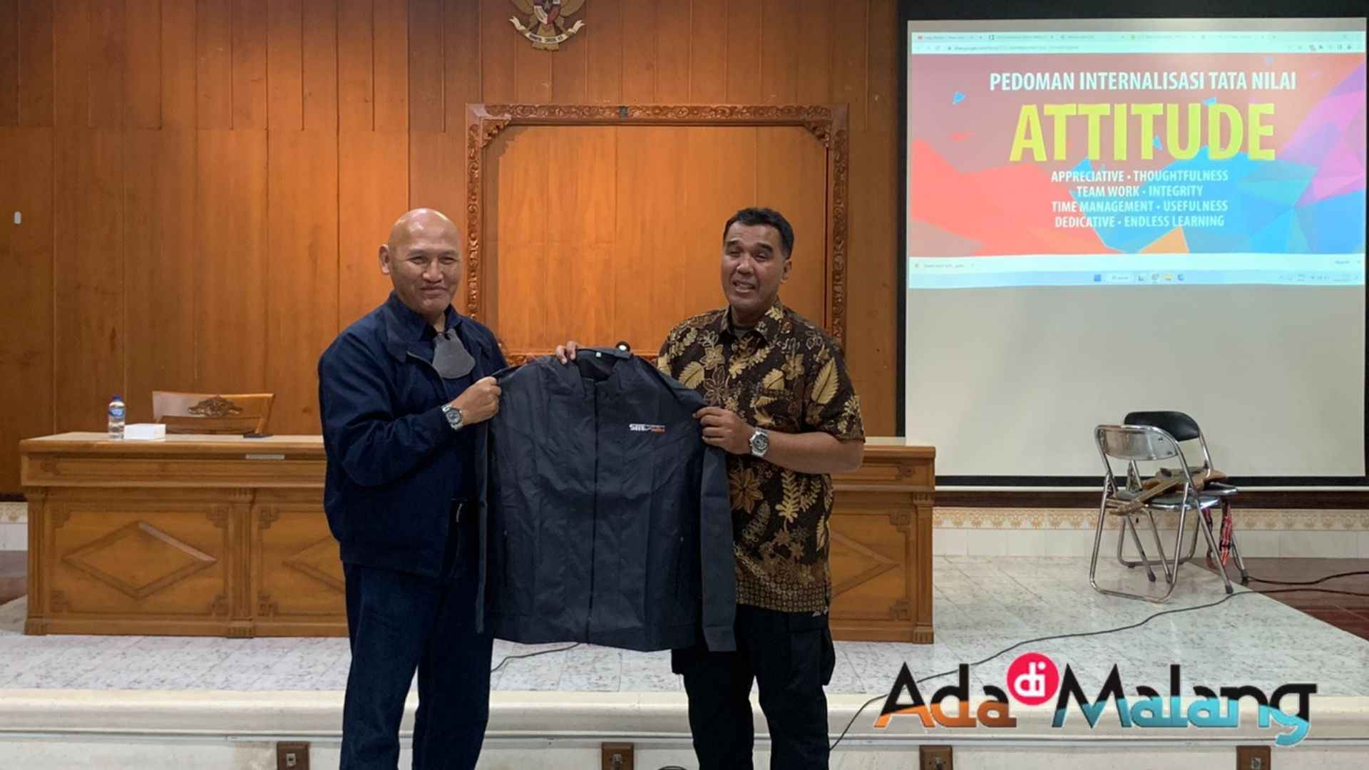 Wakil Ketua III STIE Malangkuçeçwara menyerahkan jaket kehormatan untuk Pembina OSIS SMA Patra Dharma