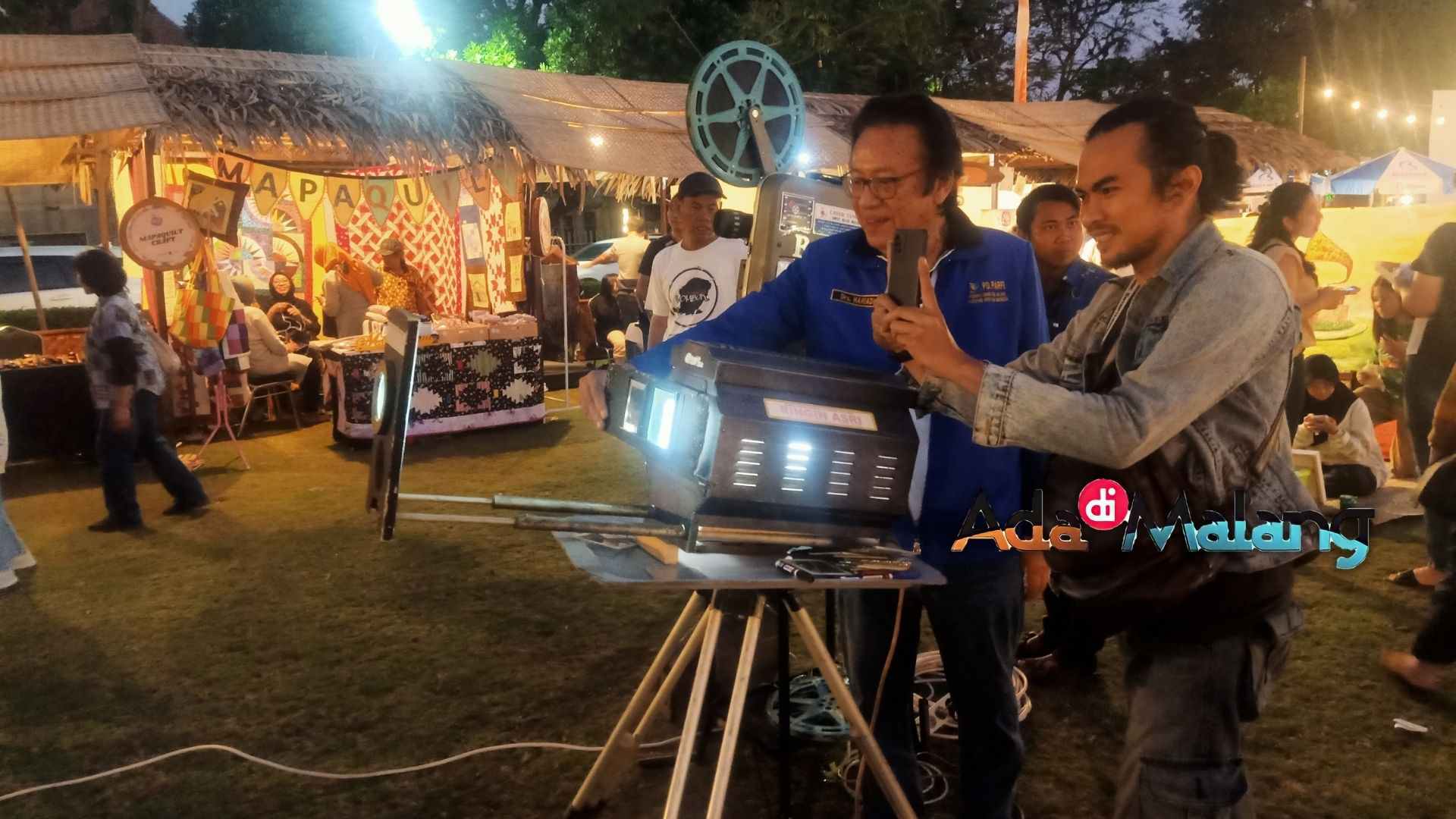 Drs Hariadi menjelaskan pola kerja proyektor film jadul kepada masyarakat yang berkunjung ke Tong Tong Night Market (Foto : Agus Yuwono)