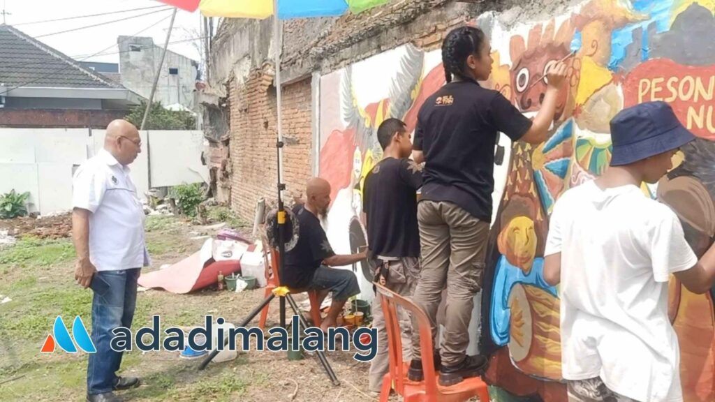 Salah satu juri Lomba Mural Whiz Prime Hotel Malang yakni Ketua PHRI Kota Malang Agoes Basoeki tengah menyaksikan para peserta saat mengerjakan karya para peserta (Foto : Agus Yuwono)