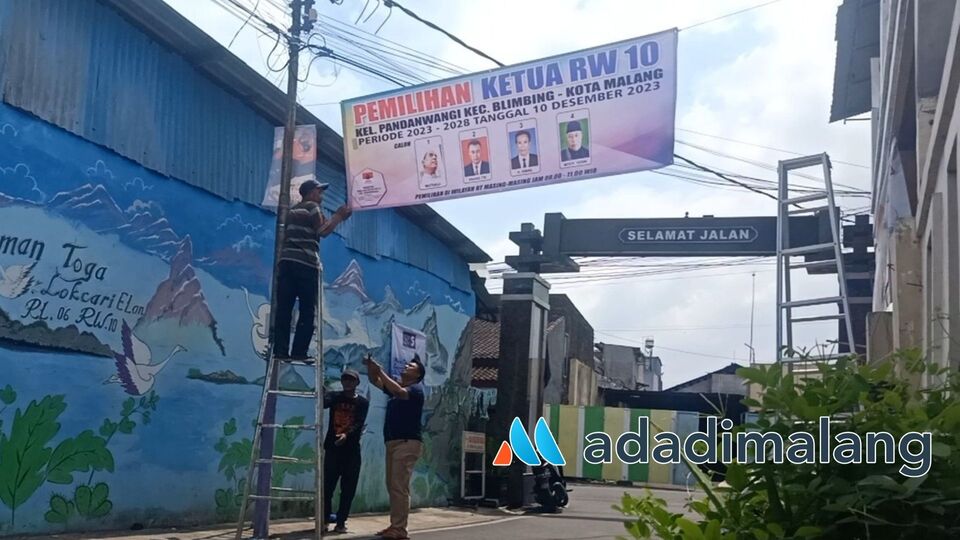 Panitia Pemilihan Ketua RW X Pandanwangi tengah memasang banner berisi foto dan visi misi kandidat sebagai sosialisasi kepada warga RW X Pandanwangi (Foto : Agus Yuwono)