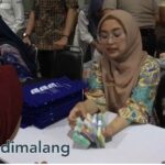 Petugas sedang melayani penukaran uang baru dalam kegiatan penukaran terpadu di Gedung Kartiini Kota Malang pagi tadi (Foto : Agus Yuwono)