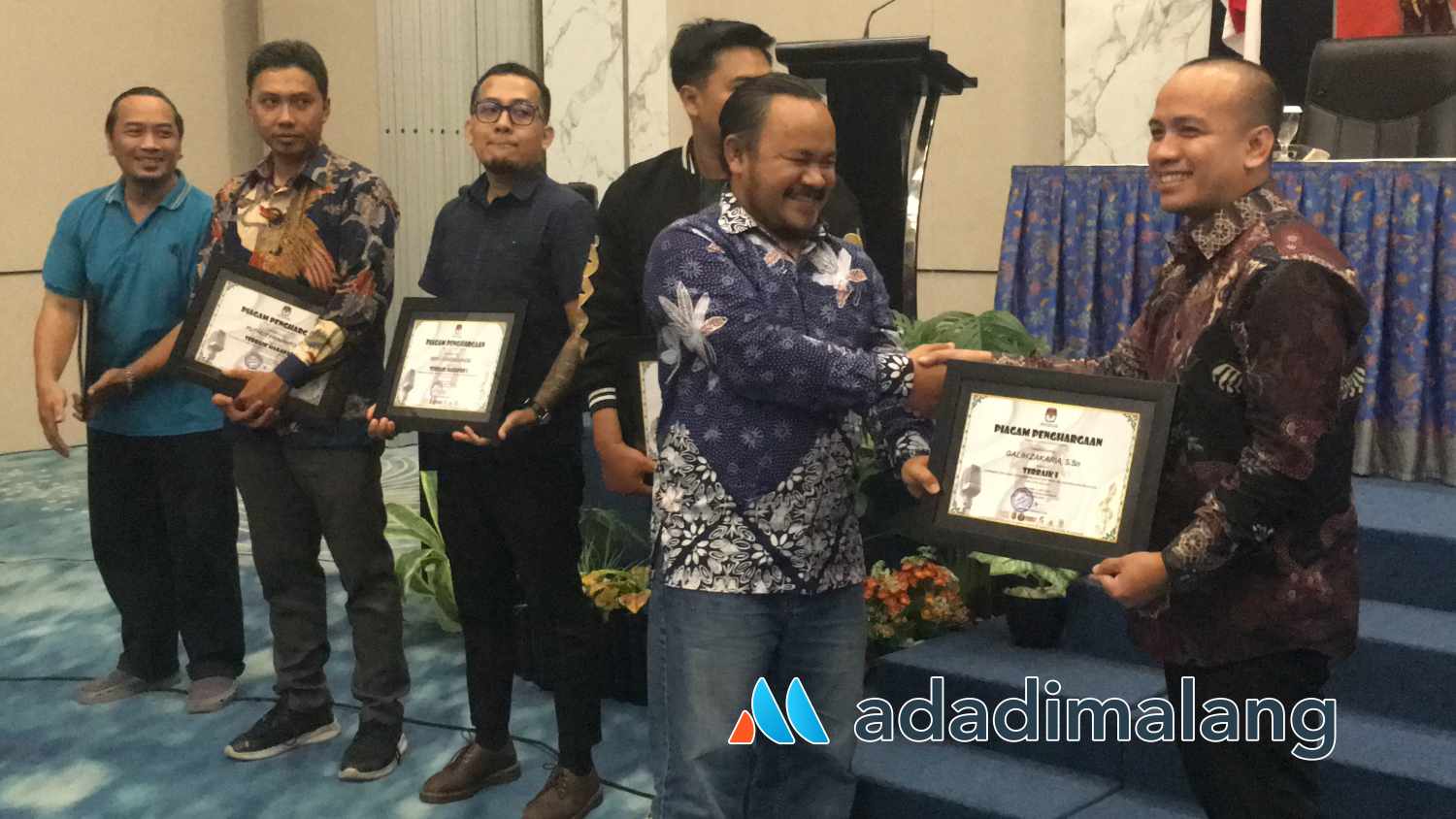 Komisioner KPU Kota Malang Divisi Sosialisasi, Pendidikan Pemilih, parmas dan SDM KPU Kota Malang, Muhammad Toyib saat menyerahkan hadiah kepada Juara Terbaik I Cipta Jingle Pilkada Kota Malang 2024 (Foto : Agus Yuwono)