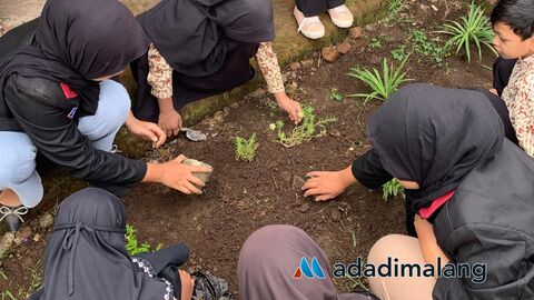 Para siswa kellas V SDN 1 Petungsewu merawat taman sekolah sebagai wujud praktik dari Program K3 (Foto  : Ist)