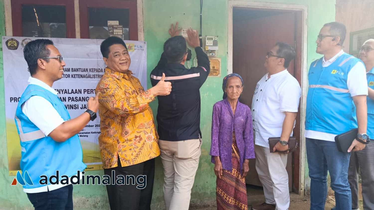 Perwakilan Dirjen Energi Ketenagalistrikan menempelkan stiker di rumah yang telah mendapatkan Bantuan Pemasangan Listrik baru (BPLB) dari Pemerintah (Foto : Agus Yuwono)