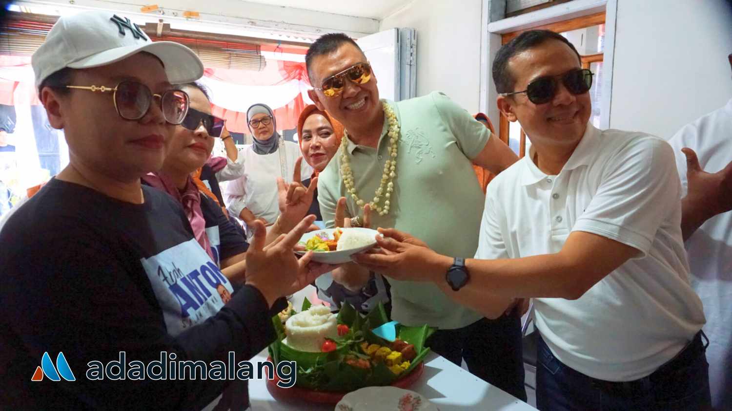 Paslon Abadi menyerahkan potongan tumpeng kepada Dwi Astutik selaku Ketua Posko Pemenangan Paslon Abadi di RW 2 Mojolangu (Foto : Agus Yuwono)