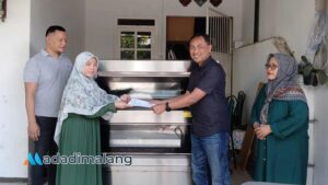 Ketua Tim Pengabdian Kepada Masyarakat (PKM) STIE Malangkuçeçwara, Dr. Hanif Mauludin, M.Si., saat menyerahkan bantuan alat produksi berupa Oven 2 Deck untuk UMKM Bolen Malang Fairuziba