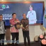 Pj Wali Kota Malang Iwan Kurniawan menyerahkan apresiasi kepada Wajib Pajak yang dinilai memiliki kinerja terbaik dalam pembayaran pajak daerah (Foto : AdaDiMalang)