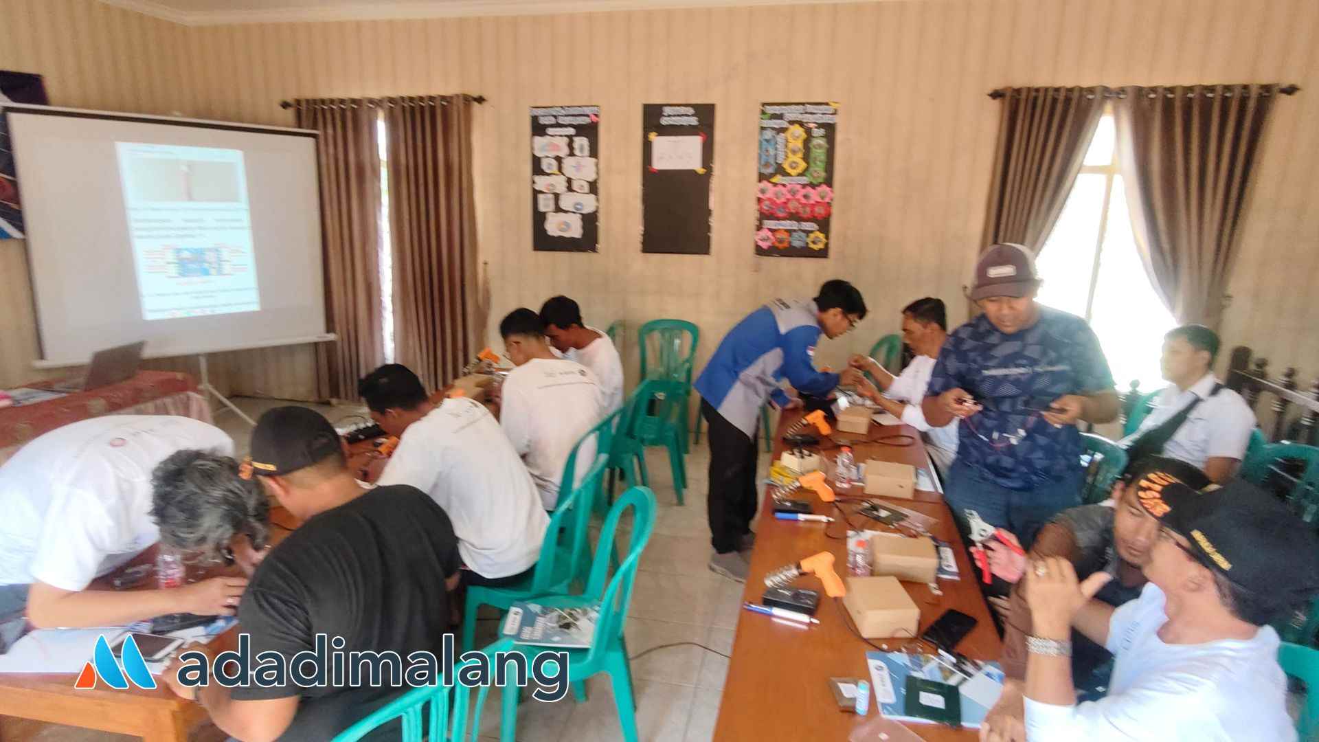 Para perangkat desa Tulusbesar Tumpang tengah asyik melakukan praktik perakitan PLTS sederhana dipandu dosen Teknik Elektro POLINEMA (Foto : Agus Yuwono)