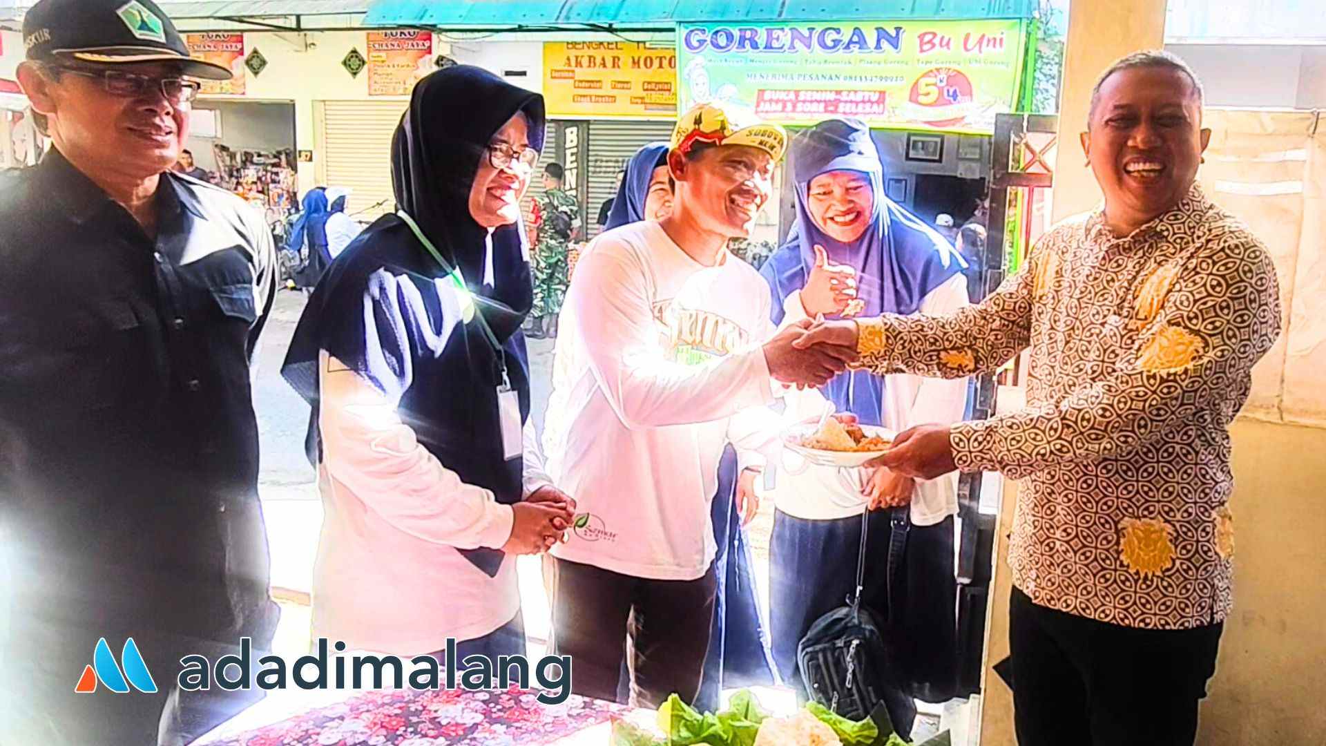 Sekretaris Kecamatan Blimbing, Johan Fuady menyerahkan potongan tumpeng nasi jangung kepada Ketua RT 6 RW 2 Arjosari Edi Sugianto usai pembukaan Festival UMKM Pasar Misem (Foto : Agus Yuwono)