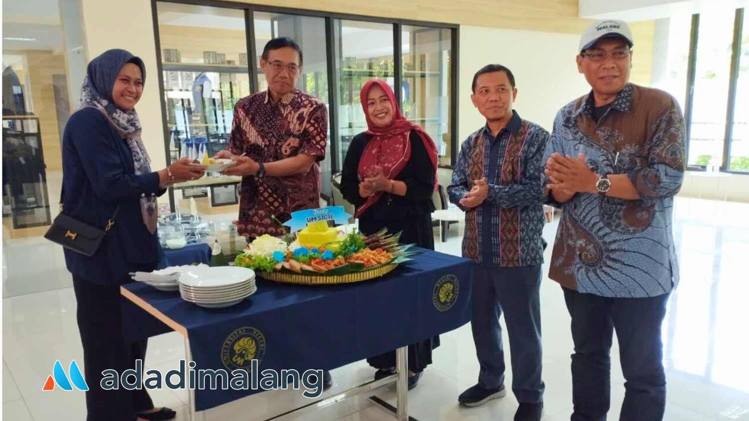 Rektor UM memberikan potongan tumpeng kepada Sekretaris Badan Pengembangan Usaha dan Dana Abadi UM (Foto : Agus Yuwono)