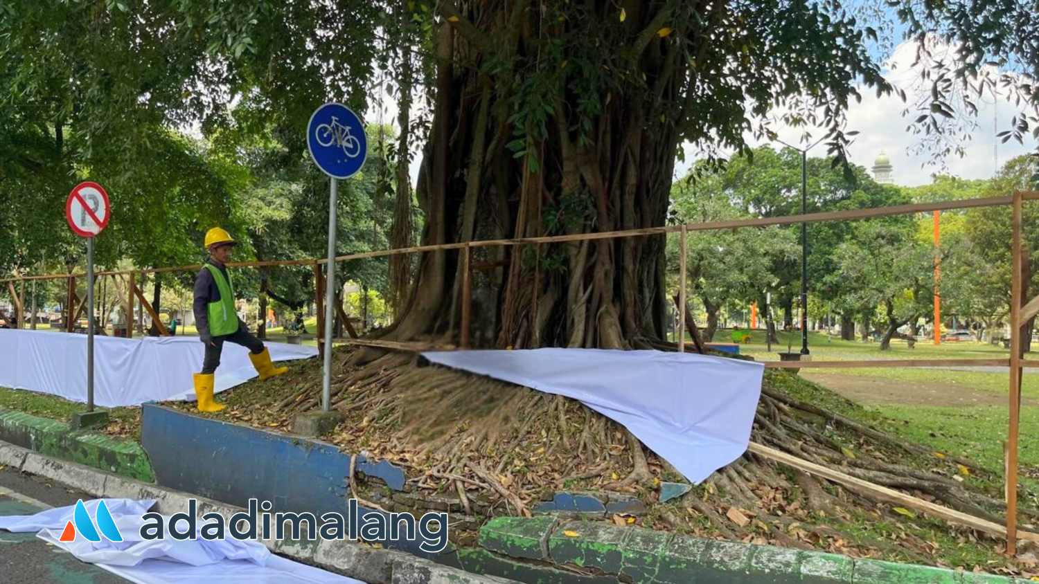 Petugas akan memasang banner pelaksanaan revitalisasi Alun-Alun Merdeka Malang beberapa waktu lalu